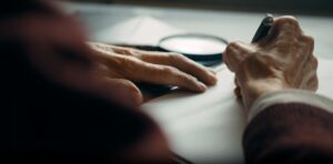 Close-up shot of an older person writing heartfelt notes in a legacy book